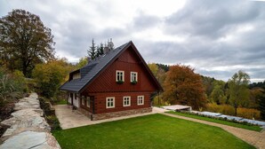 A traditional wooden house with a sloped roof, surrounded by a well-maintained lawn and stone pathway. - Vysoke nad Jizerou Kkh070 (Vysoké nad Jizerou)