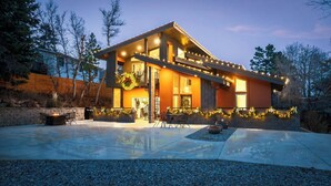Una casa moderna con un porche cubierto, mobiliario exterior y decoraciones navideñas.