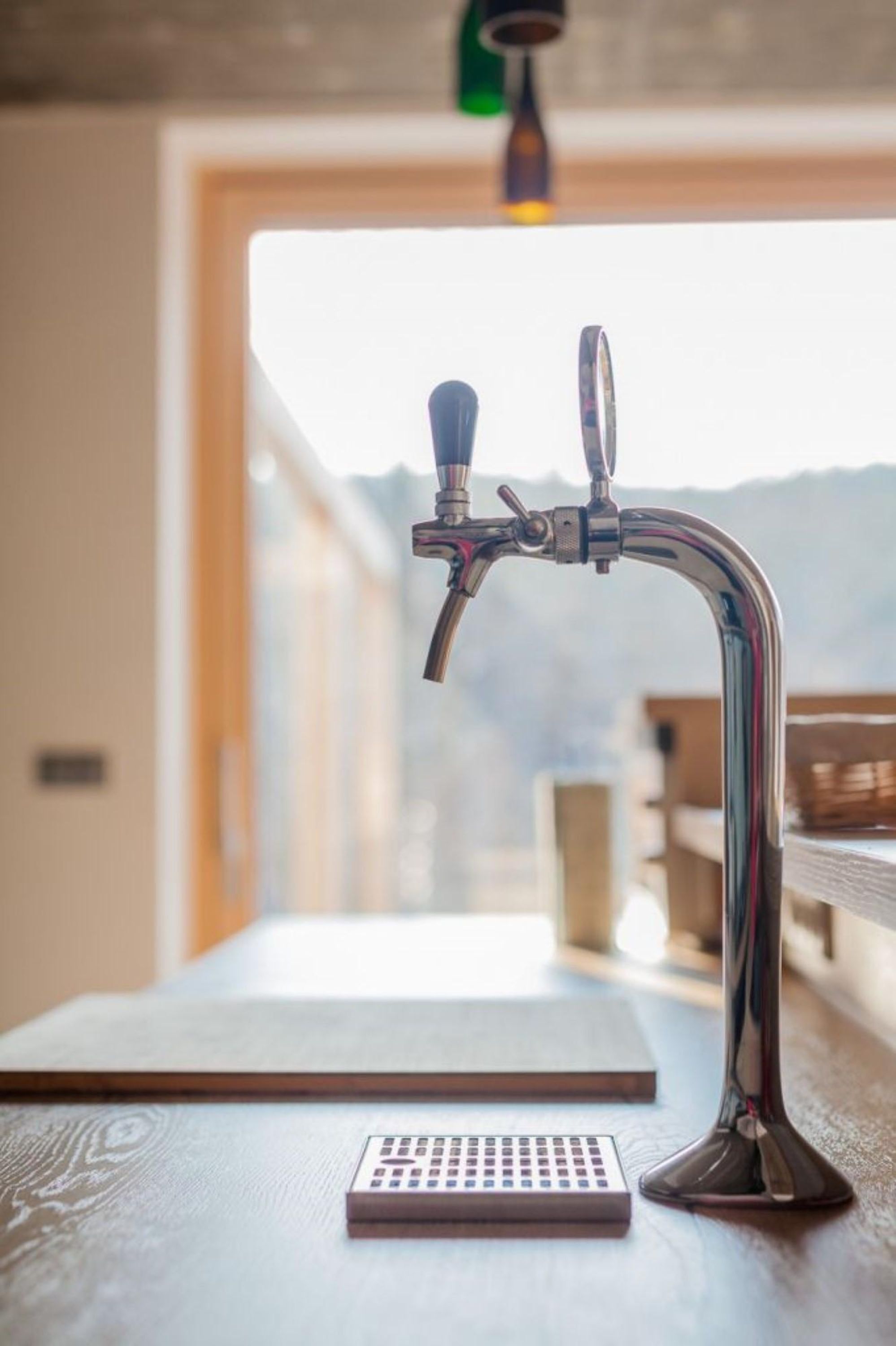 A tap with a lever and a keyhole, a small square object, and a wooden table.