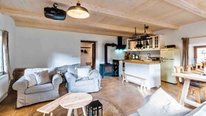 A spacious living room with a sofa set, a small round table, and a kitchen area with a stove and cabinets. - Lucany nad Nisou - Lla560 (Lučany nad Nisou)