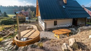 A rustic cabin with a metal roof, a wooden deck, and a stone well. - Lucany nad Nisou - Lla560 (Lučany nad Nisou)
