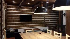 A rustic wooden interior with a wooden dining table, chairs, and pendant lights. - Villa Horni Marsov - Khp120 (Horni Marsov)