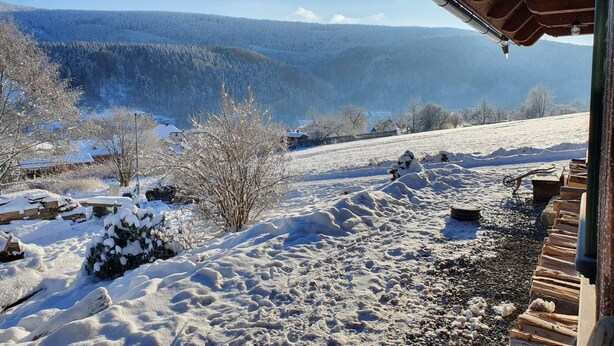 A snowy landscape with a wooden cabin and a view of a forested mountain range. - Villa Horni Marsov - Khp120 (Horni Marsov)