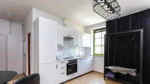 A modern kitchen with white cabinets, a black countertop, and a wooden floor. - Old Town Szczecin Apartment (Szczecin)