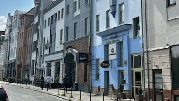 A street with historic buildings, cobblestone pavement, and a clear sky. - Old Town Szczecin Apartment (Szczecin)