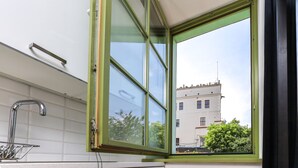 A kitchen with a window, a faucet, and cabinets. - Old Town Szczecin Apartment (Szczecin)