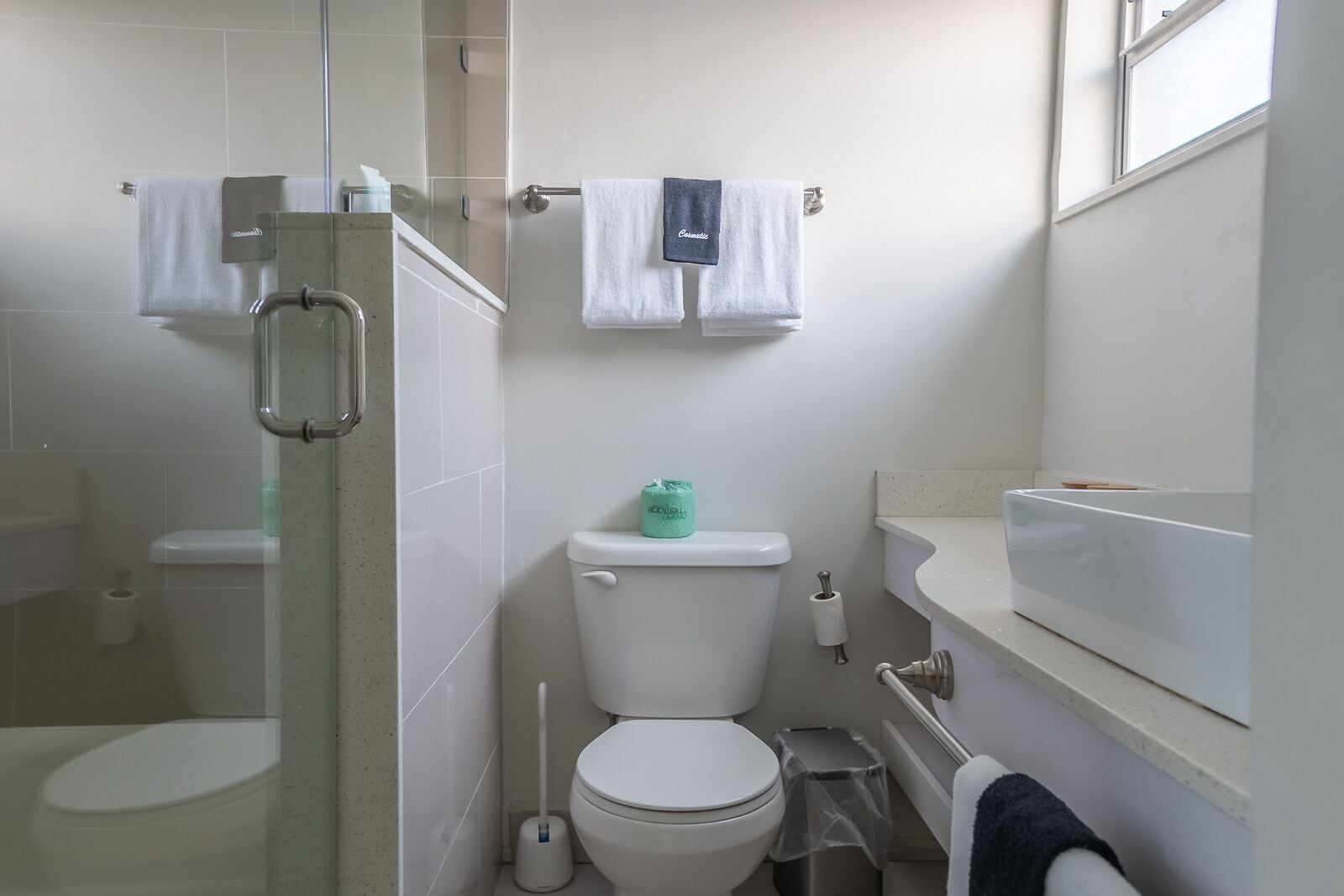 Un baño con cabina de ducha de vidrio, inodoro, bidé y lavamanos con encimera.