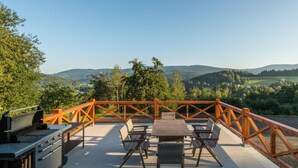An outdoor patio with a grill, seating area, and a view of the surrounding landscape. - Hutisko - Solanec Mha555 (Hutisko-Solanec)