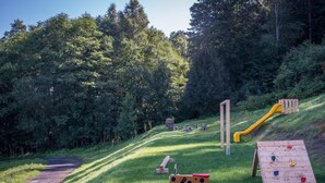 A playground with a slide, swings, and a climbing structure. - Hutisko - Solanec Mha555 (Hutisko-Solanec)