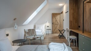 A bedroom with a sloped ceiling, a bed, a chair, a small table, and a wooden wardrobe. - Hutisko - Solanec Mha555 (Hutisko-Solanec)