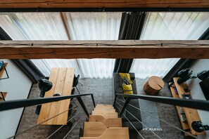 A wooden staircase leading to a living area with a sofa, a coffee table, and a bookshelf. - Pernstejn Vpm019 in B Ovec (Býšovec)