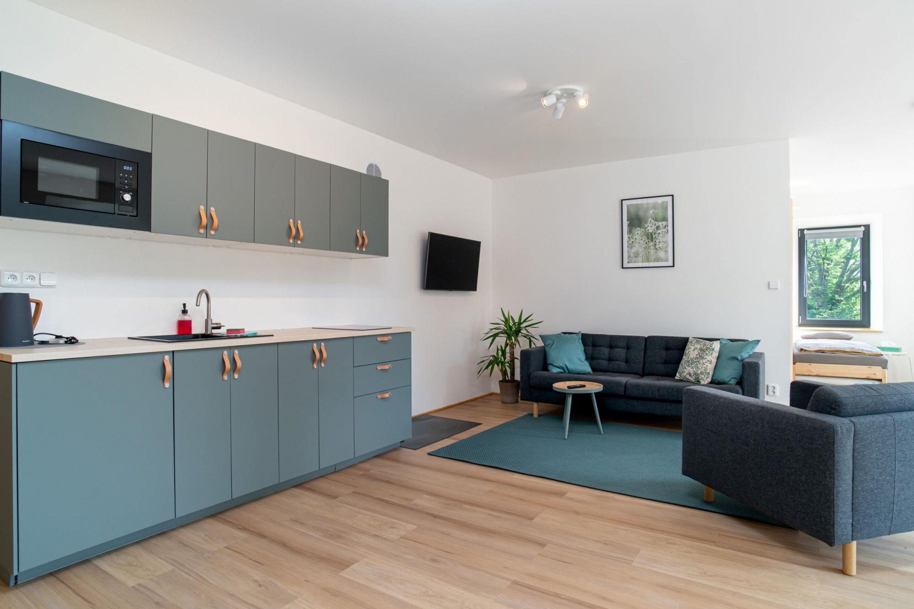 A modern kitchen with grey cabinets and a built-in microwave.