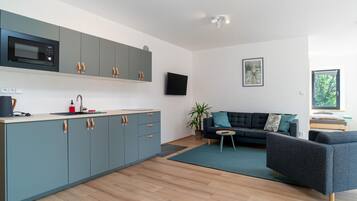 A modern kitchen with grey cabinets and a built-in microwave.
