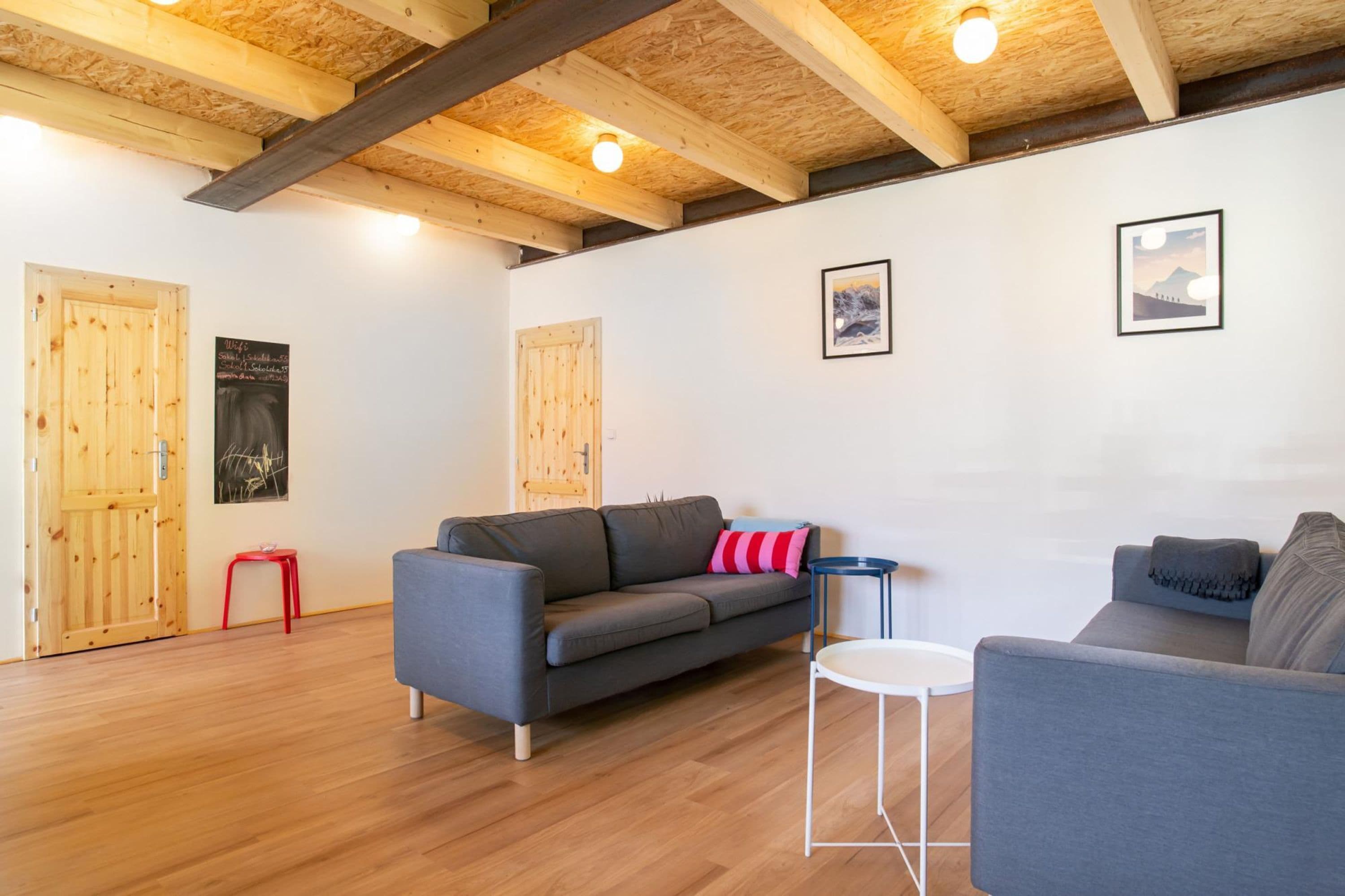 A modern living room with a grey sofa, a small round table, and wooden flooring.