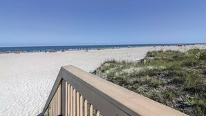 Une plage avec une promenade en bois qui mène au bord de l’eau.