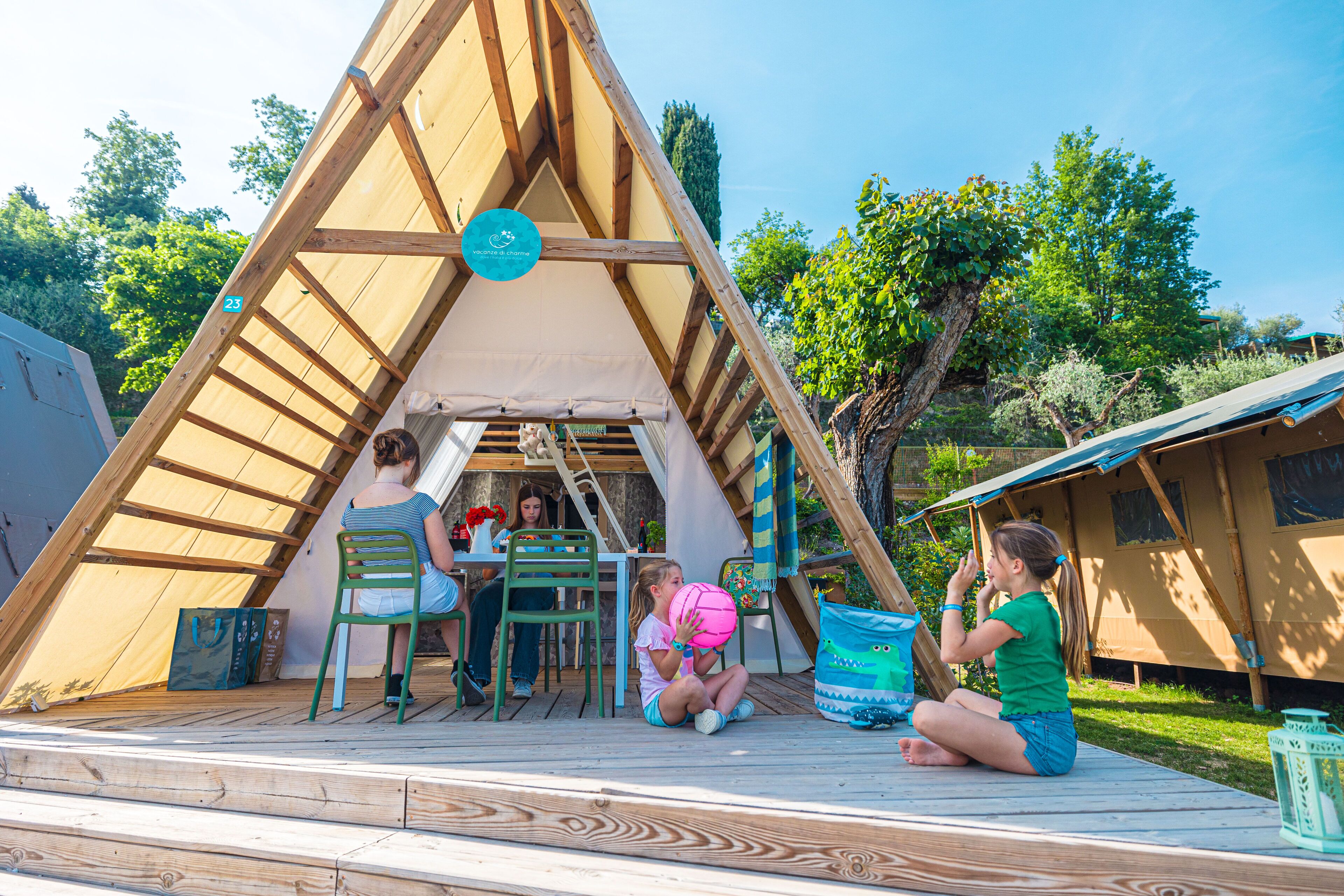 A wooden A-frame structure with a covered seating area, a table, and chairs.