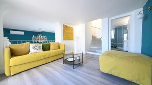 A modern living room with a yellow sofa, a glass coffee table, and a yellow bean bag. - Cozy, new apartment in the historic center and 5 minutes from the beach (Forio)