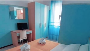 Una habitación de hotel con cama, escritorio, silla y televisión.