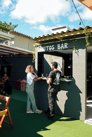 A food kiosk named 'LOBITOS BAR' with a person standing at the counter. - Sea Wolf Hostel - Lagoa da Conceição (Florianópolis)