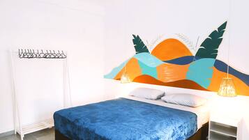 A bedroom with a bed, a white radiator, a wall-mounted light fixture, and a shelf.