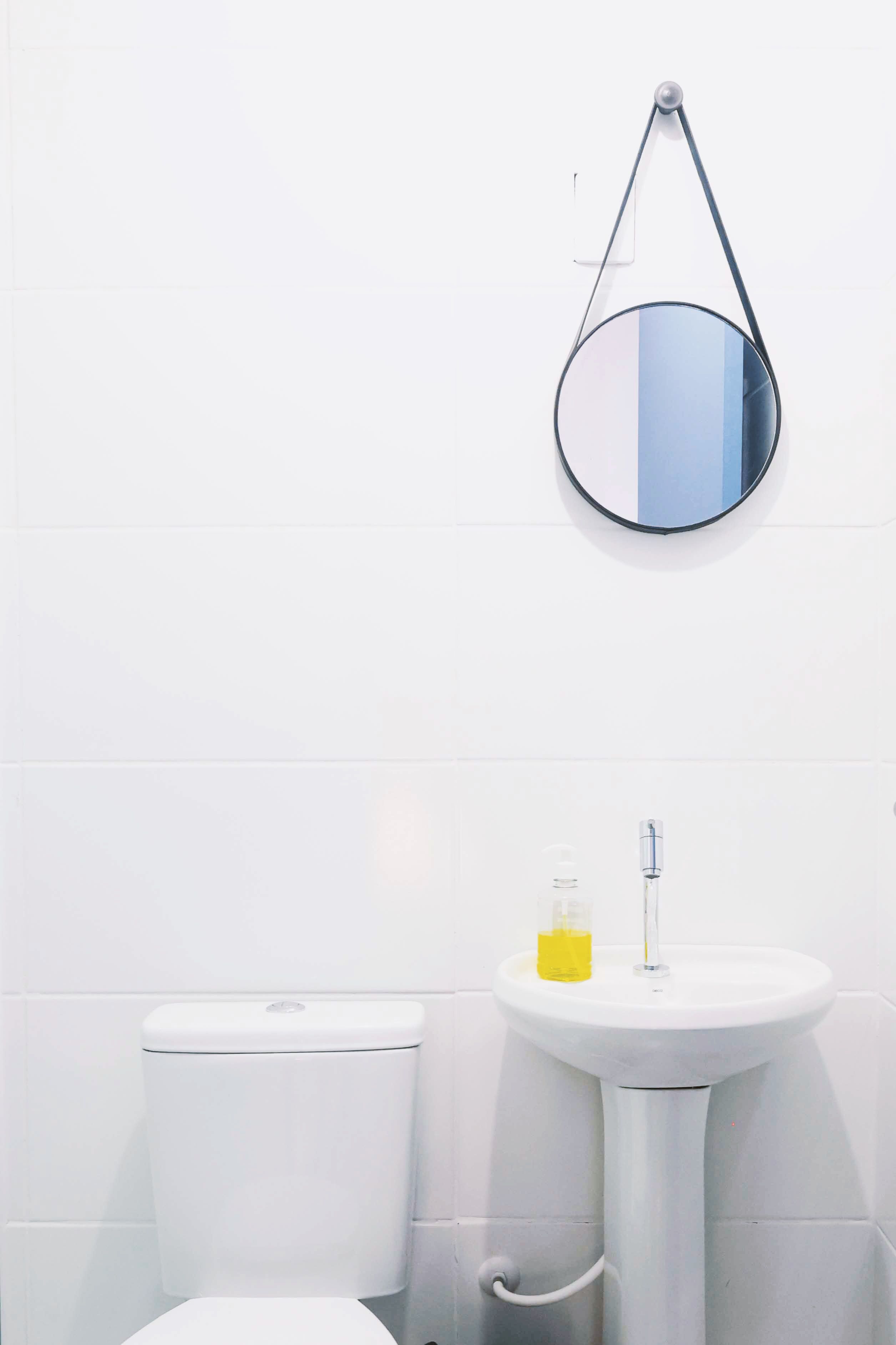 A bathroom with a toilet, a sink, and a mirror.