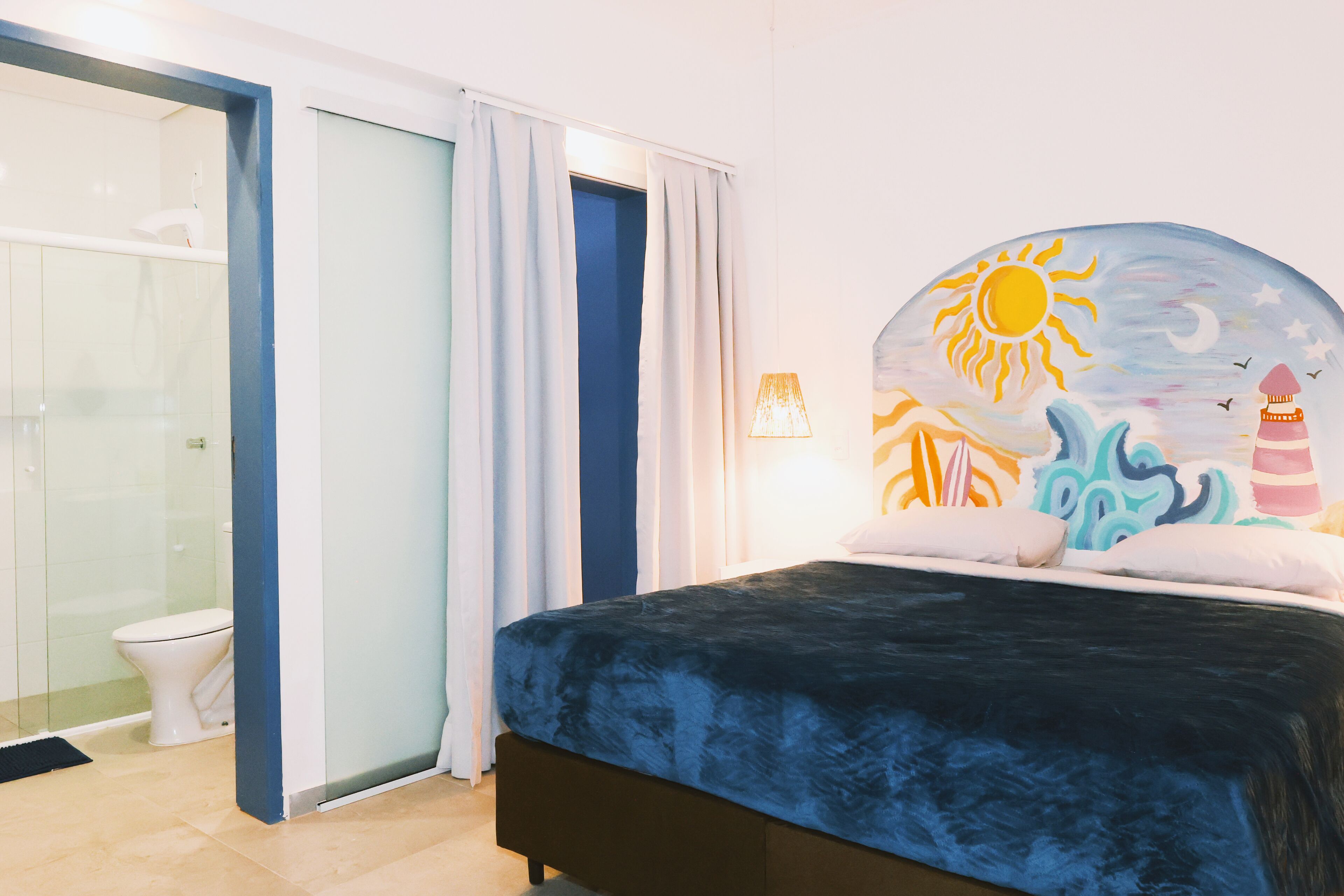 A bedroom with a bed, a bathroom with a toilet, and a shower.