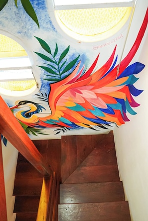 A staircase with a colorful mural featuring a bird and leaves. - Sea Wolf Hostel - Lagoa da Conceição (Florianópolis)
