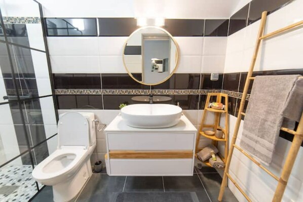 A modern bathroom with a toilet, sink, and mirror.