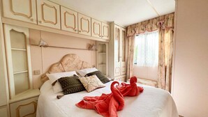 Een slaapkamer met een groot bed, een hoofdeinde en ingebouwde kasten.