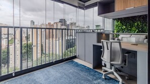 Un espacio de oficina moderno con un amplio ventanal, un escritorio y una silla.