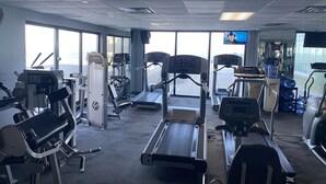 Ein Fitnessstudio mit Laufbändern, Crosstrainern und Gewichten.
