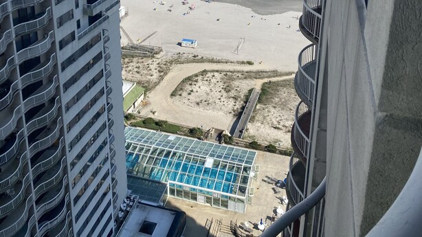 Ein Hochhaus mit Pool und Blick auf den Strand.