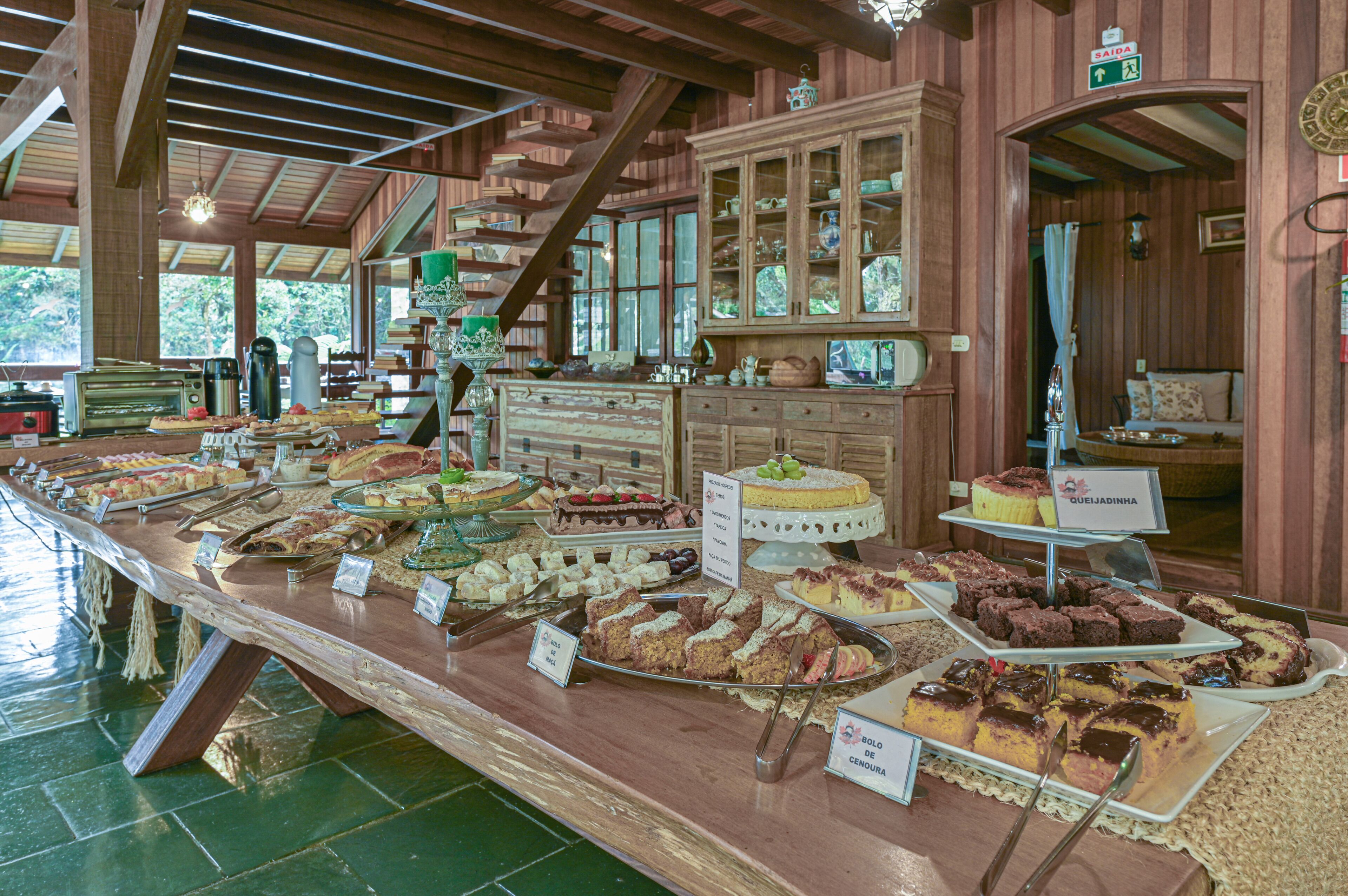 A buffet with various desserts and a wooden interior.