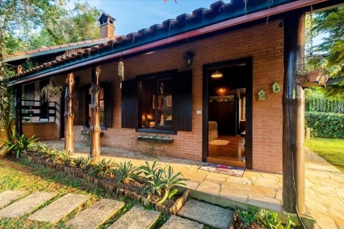 A rustic building with a brick exterior, large windows, and a covered porch area.