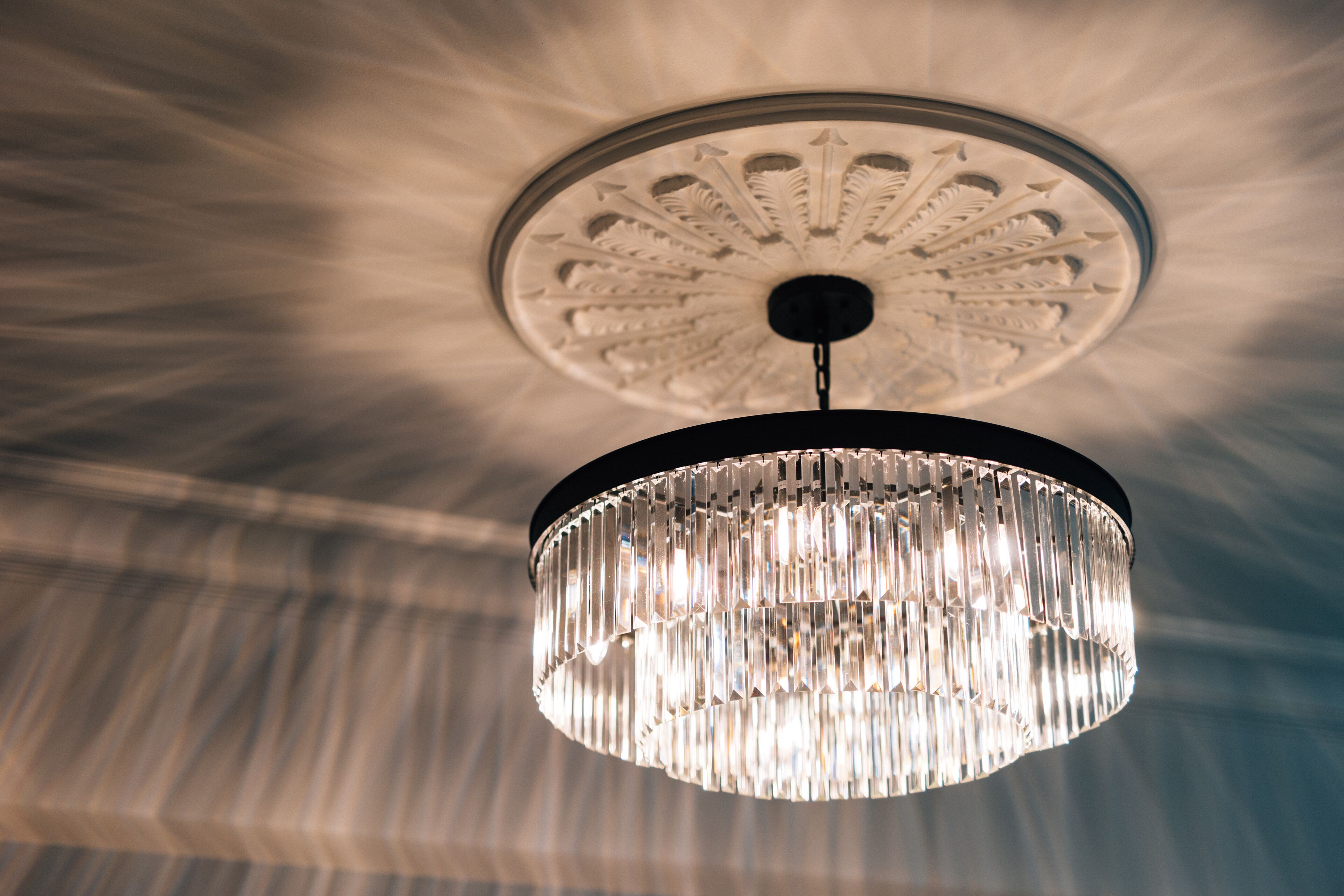 A chandelier with a circular base and a decorative ceiling medallion.