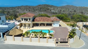 A large house with a swimming pool, multiple rooms, and a covered patio area. - Stunning 4BR Pool Villa w Patio near Palm Beach (Noord)