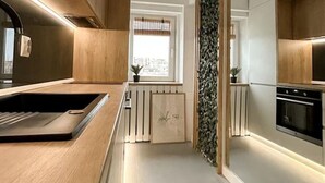 Une cuisine moderne avec des meubles en bois, un four encastré et une fenêtre offrant une belle vue.