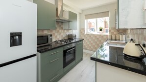 Una cocina moderna con refrigerador, microondas, estufa y dispensador de agua.
