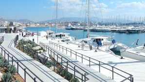 A marina with boats docked, a pedestrian walkway, and a cityscape in the background. - A2- Luxury apt w big Balcony, 4 min Walk to Beach (Split)