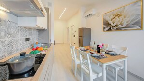 Una cocina moderna con estufa, una mesa de comedor con sillas y un cuadro grande de flores en la pared.