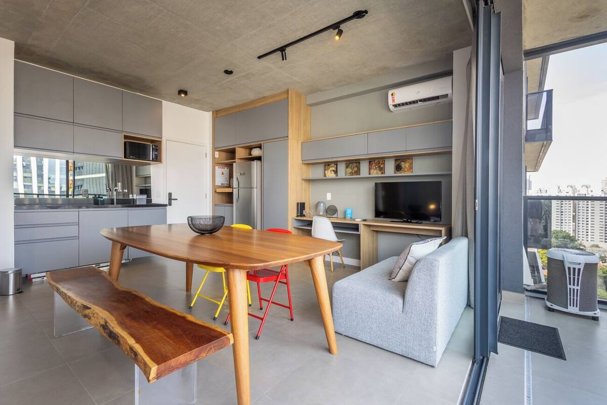 Una cocina moderna con comedor, sofá y televisor.