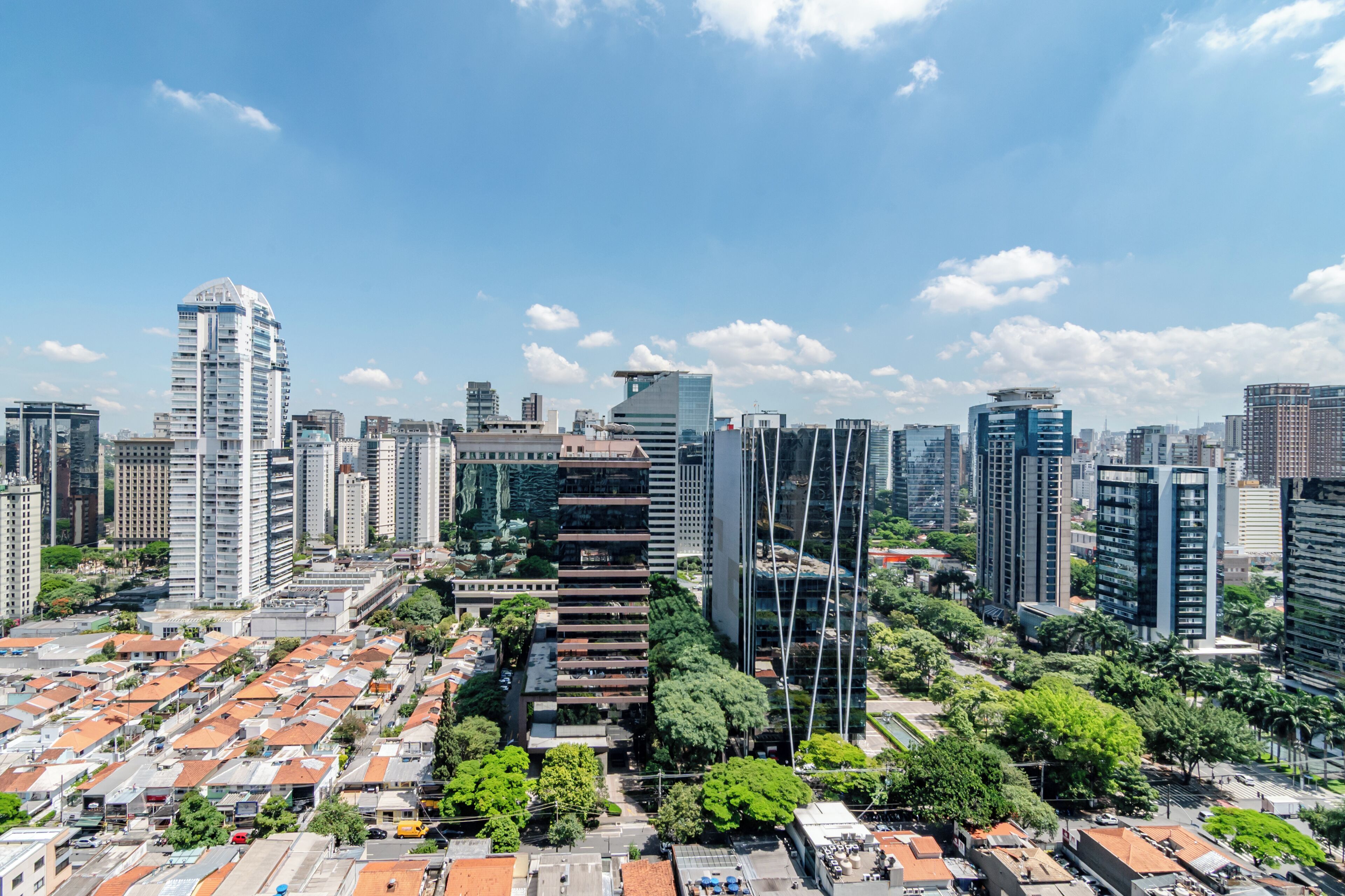 Panorama urbano con moderni grattacieli, un mix di edifici residenziali e commerciali, e cielo sereno.