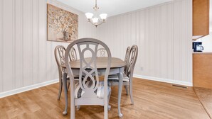 A dining area with a round table and chairs, a chandelier, and a painting on the wall. - Fantastic for Extended Stays & Work Crews- 10 beds, 5 bedrooms, 2.5 baths (Warner Robins)