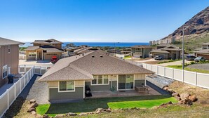 A residential area with houses, a clear sky, and a view of the ocean.
