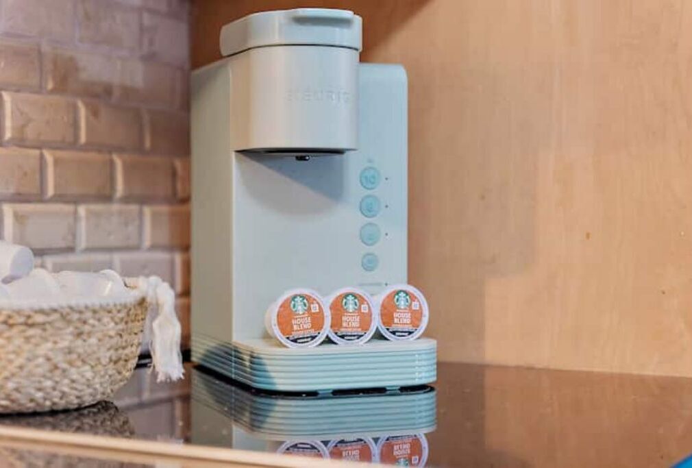 Máquina de café com quatro cápsulas sobre um balcão.