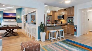 Una cocina moderna con armarios de madera, electrodomésticos de acero inoxidable y una barra.