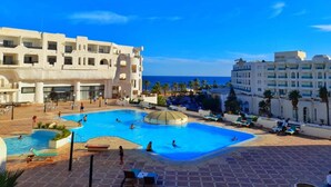A resort with a large swimming pool, multiple buildings, and a view of the sea. - Yasmine Beach - Families and Couples (Hammamet)