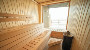 Una sauna con bancos de madera y vista a la playa.