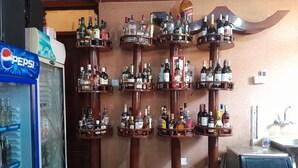 Zona de bar con múltiples estantes llenos de botellas de licor.