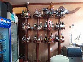A bar area with multiple shelves of liquor bottles.